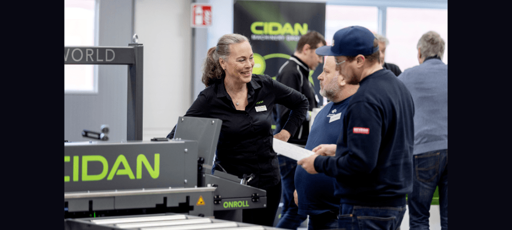 Tema innovation och premiär för ny rullformare när Cidan genomförde öppet hus Désirée Lerider i samtal med två besökare. De står vid rullformningsmaskinen ONROLL. Foto: Cidan Machinery