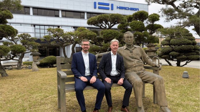 Hos Hwacheon möts koreansk maskinbyggartradition och modern produktionsteknik Simon Larsson, till vänster, och Niclas Mårtensson framför Hwacheons huvudkontor. Statyn på bänken föreställer företagets grundare Kwon Seung gwan. Foto: Hwacheon